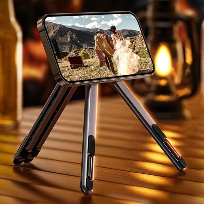 Fourfold Riser Max standing as a short tripod on a table, holding a phone that shows a photo